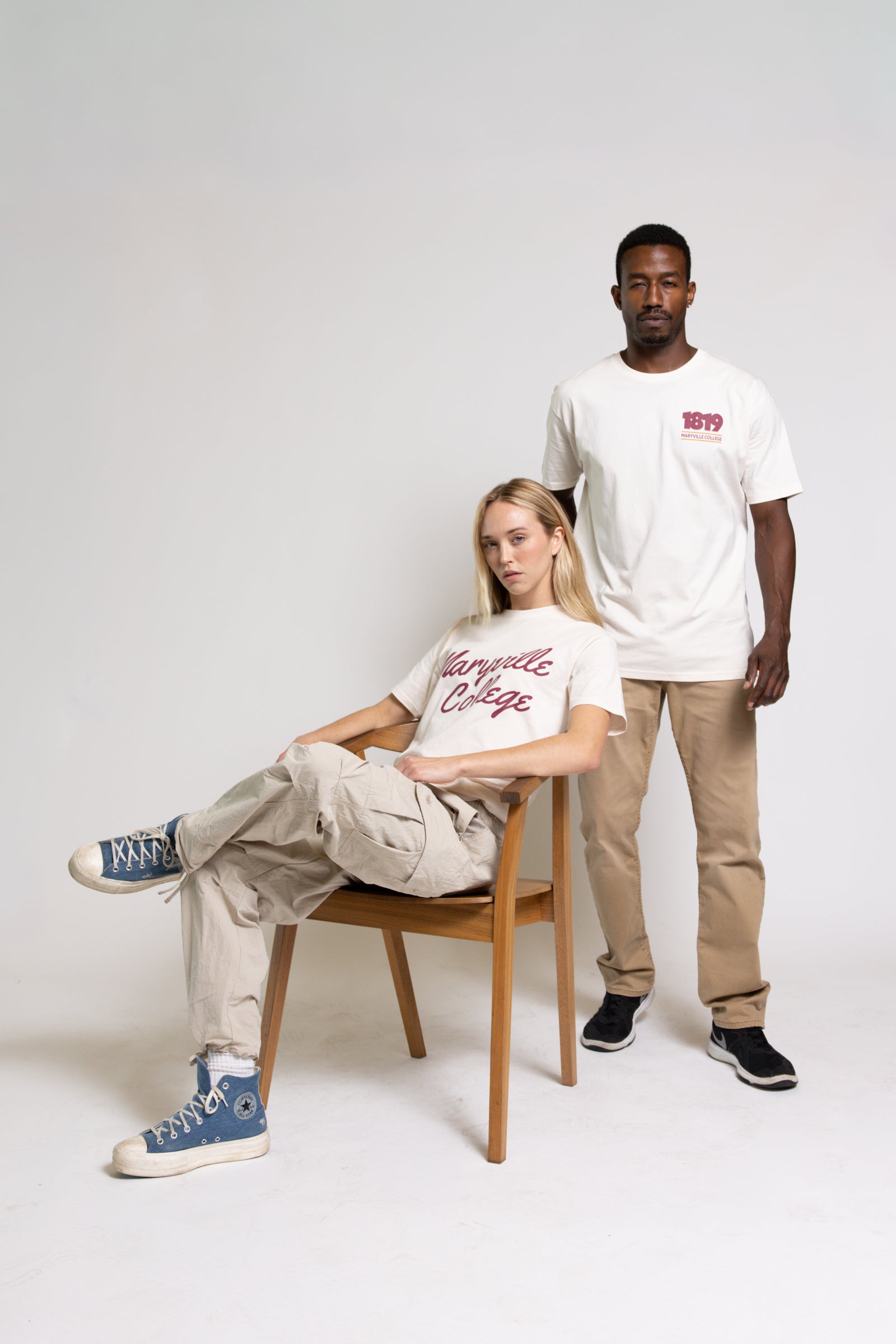 Two people wearing cream t-shirts with red Maryville College text on a white background