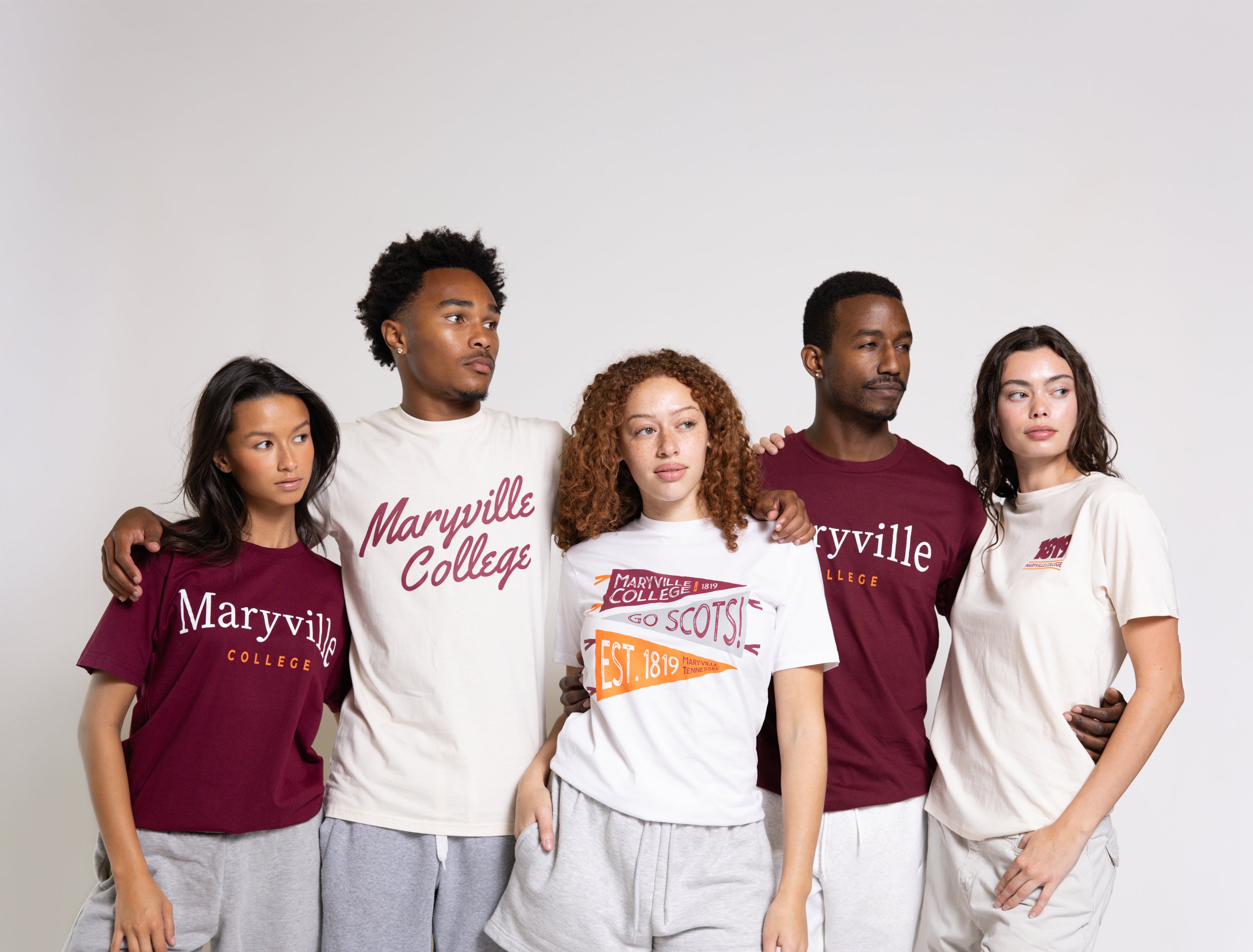 Five people wearing Maryville College t-shirts on a plain background